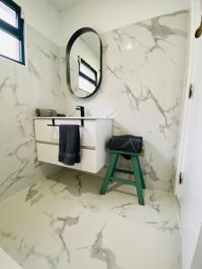 Baño blanco con espejo y taburete en Dani House - Porto Moniz Escape, en Porto Moniz