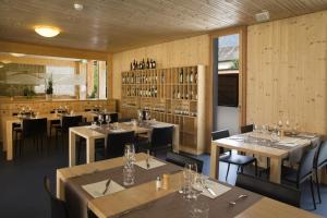 um restaurante com paredes e mesas e cadeiras de madeira em Familienhotel Campagna em Frasco