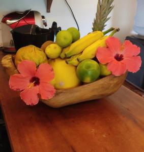 a bowl of fruit on a table with flowers at Maison Annick in Fortim +17 photos