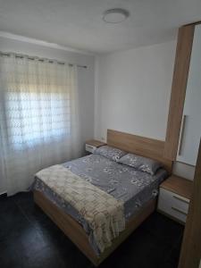 Un dormitorio con una cama y una ventana en Vila Eriona, en Baks-Rrjoll