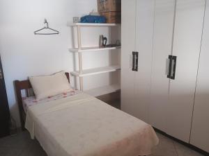 una camera con letto, armadi bianchi e sedia di Casa na praia de Touros a Touros