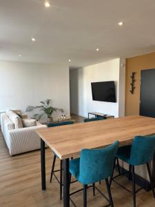 a living room with a wooden table and chairs at Appartement de la gare in Remiremont