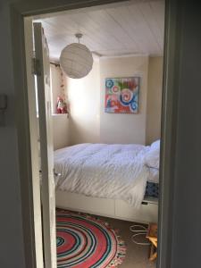 a small bedroom with a bed and a pendant light at Cornish Cottage in Newquay