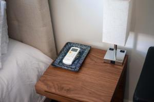 a bedside table with a cell phone on it next to a bed at Suite Jungle Studio with Views Walk Everywhere in Playa del Carmen