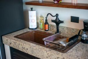 a kitchen sink with a dish drying rack next to it at Suite Jungle Studio with Views Walk Everywhere in Playa del Carmen