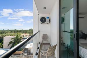 a balcony with a view of a bed and a camera at Suite Jungle Studio with Views Walk Everywhere in Playa del Carmen