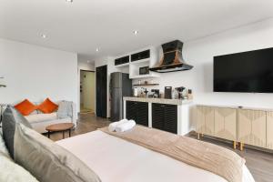 a living room with a couch and a flat screen tv at Suite Jungle Studio with Views Walk Everywhere in Playa del Carmen