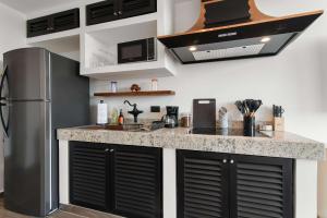 a kitchen with a refrigerator and a counter top at Suite Jungle Studio with Views Walk Everywhere in Playa del Carmen