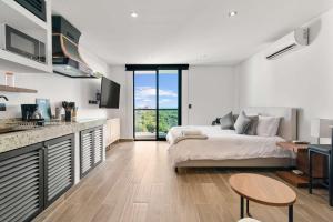 a bedroom with a bed and a kitchen with a counter at Suite Jungle Studio with Views Walk Everywhere in Playa del Carmen