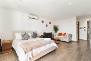 a white bedroom with a large bed and a couch at Suite Jungle Studio with Views Walk Everywhere in Playa del Carmen