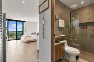 a bathroom with a toilet and a shower and a bed at Suite Jungle Studio with Views Walk Everywhere in Playa del Carmen