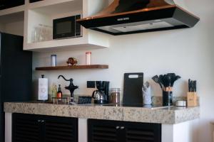 a kitchen with a granite counter top and a stove at Suite Jungle Studio with Views Walk Everywhere in Playa del Carmen