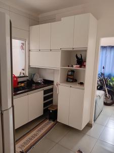 a kitchen with white cabinets and a motorcycle in it at Casa Linda em campo grande in Campo Grande