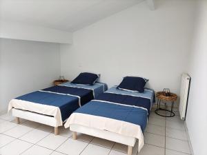 una habitación con dos camas y una mesa en Biscarosse Ville - Maison 10 pers - 4 ch - Jardin - Lac - Océan, en Biscarrosse