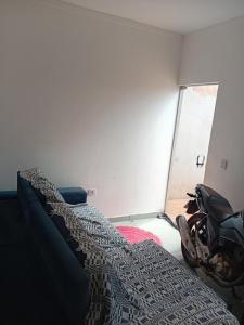 a room with two beds and a motorcycle in it at Casa Linda em campo grande in Campo Grande