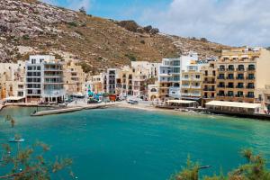 a group of buildings next to a body of water at Il figolla b&b in Xagħra