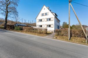 a white house on the side of a road at Ferienwohnung Ankerplatz, 65qm in Langscheid