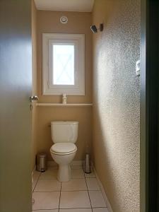 Un baño con inodoro y ventana. en Biscarosse Ville - Maison 10 pers - 4 ch - Jardin - Lac - Océan, en Biscarrosse 19 fotos más