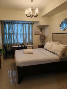 - une chambre avec un grand lit et un lustre dans l'établissement Lourdes Bedsit Horizon 101, à Cebu