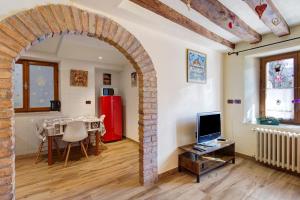 einen Torbogen in einem Wohnzimmer mit einem Tisch und einem TV in der Unterkunft Il cuore delle dolomiti in Vinigo