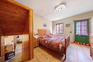 ein Schlafzimmer mit einem Bett und einem Holzboden in der Unterkunft Il cuore delle dolomiti in Vinigo