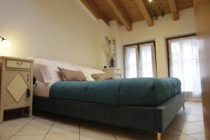 a bed with a blue couch in a room with windows at Midnight blues for 3 people near the airport in Azzano San Paolo