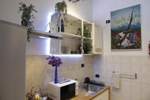 a kitchen with a sink and a microwave at Midnight blues for 3 people near the airport in Azzano San Paolo