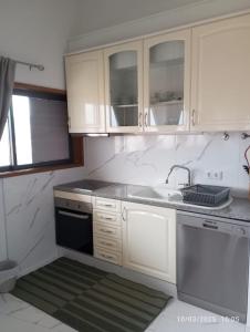 a kitchen with white cabinets and a sink at Sweets Suites Espinho in Espinho +53 photos