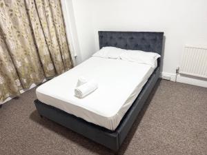 a bed with a black frame and white sheets at Central 4 Bed House - Sleeps 8 & Free Parking in Southampton +2 photos