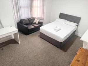 a bedroom with a bed and a chair and a couch at Central 4 Bed House - Sleeps 8 & Free Parking in Southampton