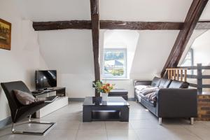 a living room with a couch and a tv at Appartement de charme in Honfleur