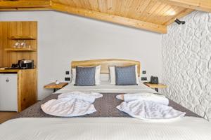 a bedroom with a bed with two towels on it at Emily's Luxury Suites in Pefkochori