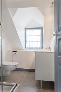 a bathroom with a toilet and a sink and a window at Appartement de charme in Honfleur +39 photos