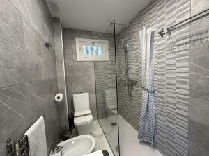 Un baño con inodoro, lavabo y ducha. en Apartamento en pleno centro de Torremolinos, en Torremolinos