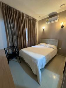 a bedroom with a white bed and a window at Casa Rio in Mangue