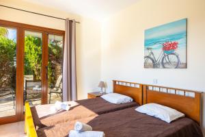 a bedroom with two beds and a bike on the wall at Villa Sunlove in Peyia +23 photos