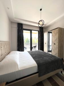 a bedroom with a large bed and a balcony at Dalaman Ege Pam Residence in Dalaman +17 photos
