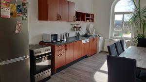a kitchen with wooden cabinets and a table with a microwave at Haltestelle - Ferienwohnung in Röbel