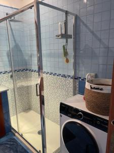a washing machine in a bathroom with a shower at Marebleuhouse in Naples