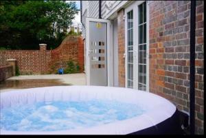 a hot tub in front of a brick house at Canterbury City Combined Luxury apartments with Hot Tub in Blean