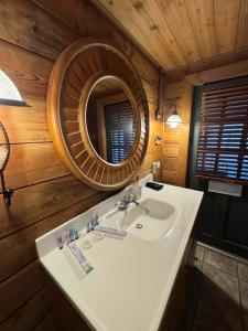 ein Badezimmer mit Waschbecken und Spiegel in der Unterkunft Luxury Cabin HotTub, Hiking, Fire Pit, Game Room in Ellijay