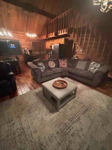 ein Wohnzimmer mit Sofa und Tisch in der Unterkunft Luxury Cabin HotTub, Hiking, Fire Pit, Game Room in Ellijay + 19 Fotos