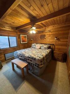 ein Schlafzimmer mit einem Bett in einer Blockhütte in der Unterkunft Luxury Cabin HotTub, Hiking, Fire Pit, Game Room in Ellijay