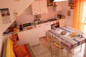 een keuken met een tafel en een keuken met een fornuis bij Casa vacanze santantioco in SantʼAntìoco