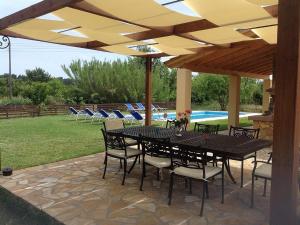 a patio with a table and chairs under an umbrella at Villa Chloe with Private Heated pool in Áfra
