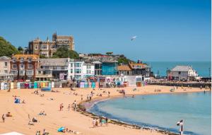 a group of people on a beach near the water at Stunning Seafront Apt-just Steps To Viking Bay in Kent