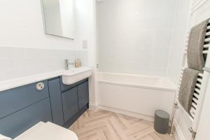 a bathroom with a sink and a bath tub at Stunning Seafront Apt-just Steps To Viking Bay in Kent +12 photos
