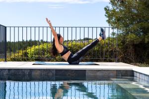 a woman doing a handstand in front of a swimming pool at Château la Négly in Fleury