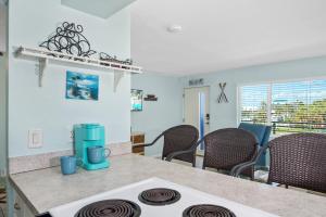 una cocina con estufa horno superior junto a una mesa en Crescent Shore 201 by Sun Palace Vacations, en Fort Myers Beach 15 fotos más