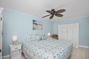 Un dormitorio con una cama y un ventilador de techo. en Crescent Shore 201 by Sun Palace Vacations, en Fort Myers Beach